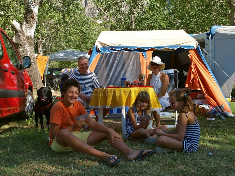 Happy smiling family (mother and father with three children) with dog (black labrador) full enjoy - spending summer vacation at a camp in nature Croatia-Dalmatia. Horizontal color photo. Happy smiling family (mother and father with three children) with dog (black labrador) full enjoy - spending summer vacation at a camp in nature Croatia-Dalmatia. Horizontal color photo.