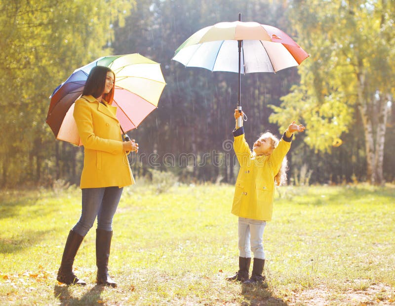 Familie met kleurrijke paraplu die pret hebben die van weer genieten stock foto's Familie met kleurrijke paraplu die pret hebben die van weer genieten stock foto's