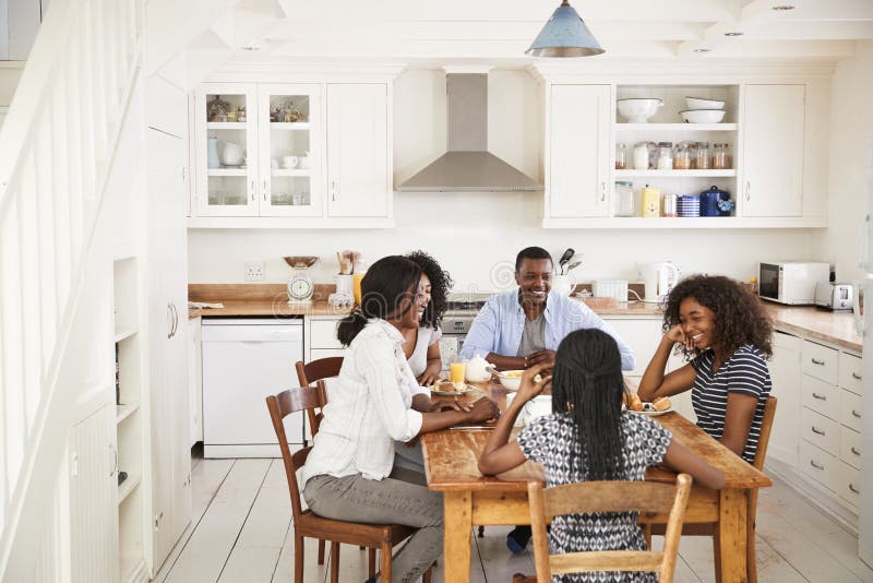 Familie met Tienerkinderen die Ontbijt in Keuken eten stock foto Familie met Tienerkinderen die Ontbijt in Keuken eten stock foto