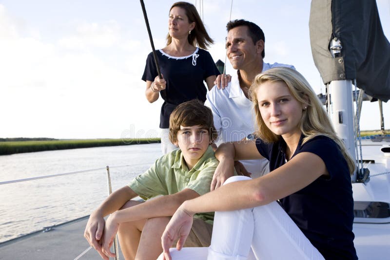 Familie mit den Jugendkindern, die auf Boot sitzen lizenzfreies stockbild Familie mit den Jugendkindern, die auf Boot sitzen lizenzfreies stockbild