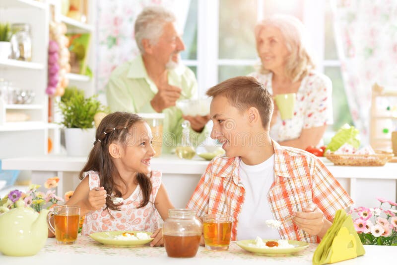 Familie mit den Kindern, die frühstücken lizenzfreies stockfoto Familie mit den Kindern, die frühstücken lizenzfreies stockfoto