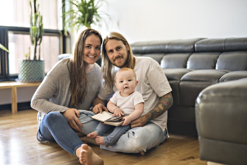 Familie mit ihrem Baby und ein Buch im Wohnzimmer stockfoto Familie mit ihrem Baby und ein Buch im Wohnzimmer stockfoto