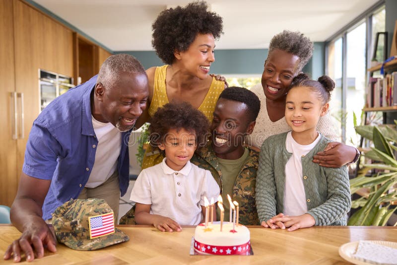 Familie mit Militärvater aus mehreren Generationen feiert Geburtstag mit Kuchen zu Hause stockfotos