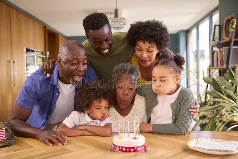 Familie mit Militärvater aus mehreren Generationen feiert Geburtstag mit Kuchen zu Hause lizenzfreie stockbilder