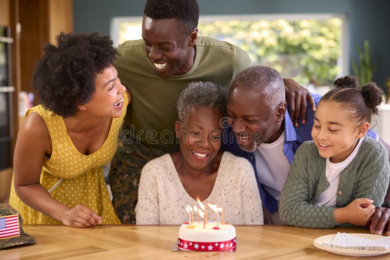 Familie mit Militärvater aus mehreren Generationen feiert Geburtstag mit Kuchen zu Hause stockbilder