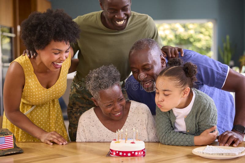 Familie mit Militärvater aus mehreren Generationen feiert Geburtstag mit Kuchen zu Hause stockbild