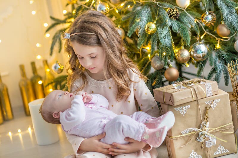 Familie op Kerstmisvooravond bij open haard De jonge geitjes die Kerstmis openen stelt voor Kinderen onder Kerstboom met giftdoze royalty-vrije stock foto's Familie op Kerstmisvooravond bij open haard De jonge geitjes die Kerstmis openen stelt voor Kinderen onder Kerstboom met giftdoze royalty-vrije stock foto's