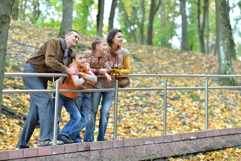 Familie van vier die in de herfstpark lopen stock fotografie Familie van vier die in de herfstpark lopen stock fotografie
