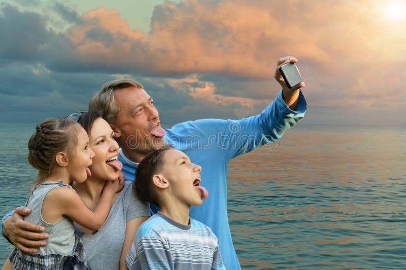 Familie van vier op een achtergrond van een kust royalty-vrije stock fotografie Familie van vier op een achtergrond van een kust royalty-vrije stock fotografie