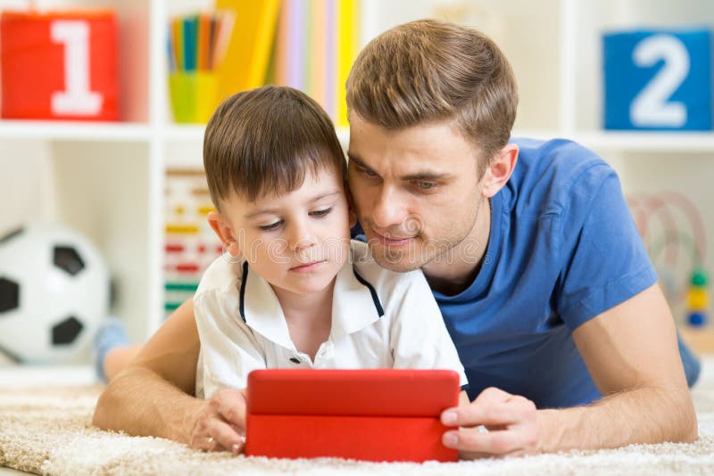Familie - Vater und Sohn mit Tabletten-PC auf Boden an lizenzfreies stockbild Familie - Vater und Sohn mit Tabletten-PC auf Boden an lizenzfreies stockbild
