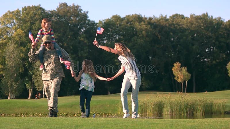 Familie von USA, die Hintergründe im Park, Vorderansicht wellenartig bewegen