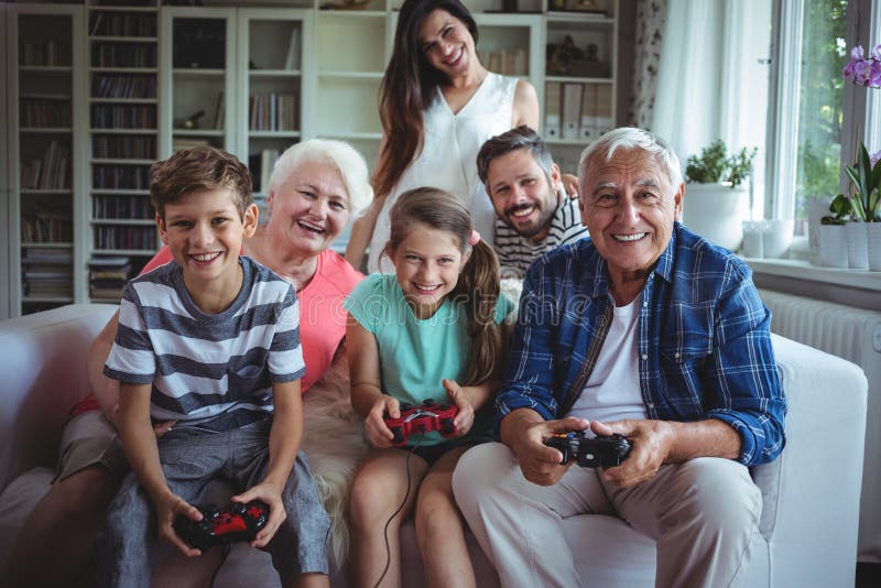 Familie, welche die Kinder aufpasst, Videospiel zu spielen lizenzfreies stockbild Familie, welche die Kinder aufpasst, Videospiel zu spielen lizenzfreies stockbild