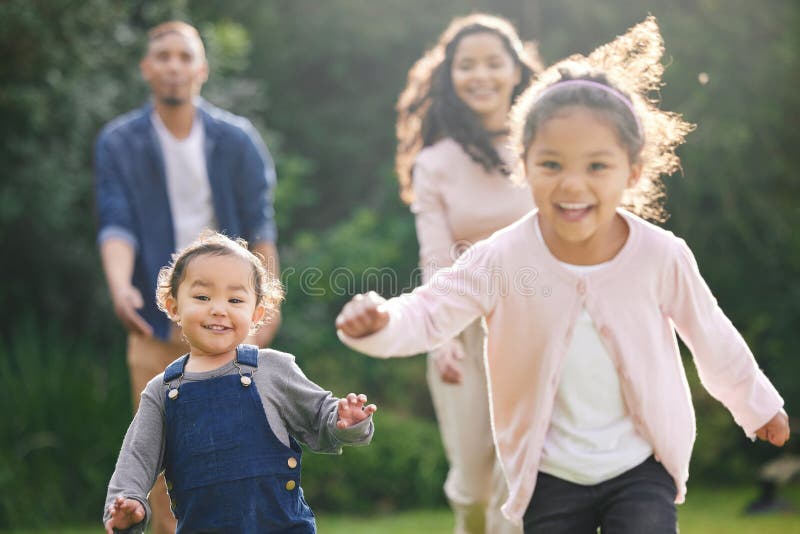 Familiengarten und Kinder, die mit Eltern laufen und Spaß Spiel mit Liebe und Pflege im Freien. Garten und Natur lizenzfreie stockfotos