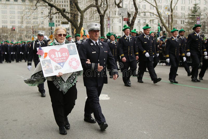NEW YORK - MARCH 17, 2016: Families of the fallen FDNY firefighters who lost life at World Trade Center on September 11, 2001 marching at the St. Patrick's Day Parade in New York. NEW YORK - MARCH 17, 2016: Families of the fallen FDNY firefighters who lost life at World Trade Center on September 11, 2001 marching at the St. Patrick's Day Parade in New York.