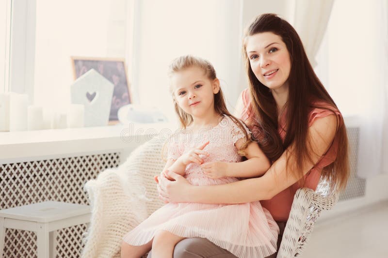 Familiezitting op stoel thuis Toevallige levensstijlvangst van moeder en peuterdochter stock afbeeldingen Familiezitting op stoel thuis Toevallige levensstijlvangst van moeder en peuterdochter stock afbeeldingen