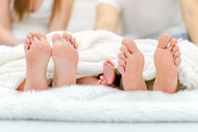 Familiy felice in base Piedi del padre e del bambino della madre sotto la coperta Paia dell'albero delle gambe fotografia stock libera da diritti Familiy felice in base Piedi del padre e del bambino della madre sotto la coperta Paia dell'albero delle gambe fotografia stock libera da diritti