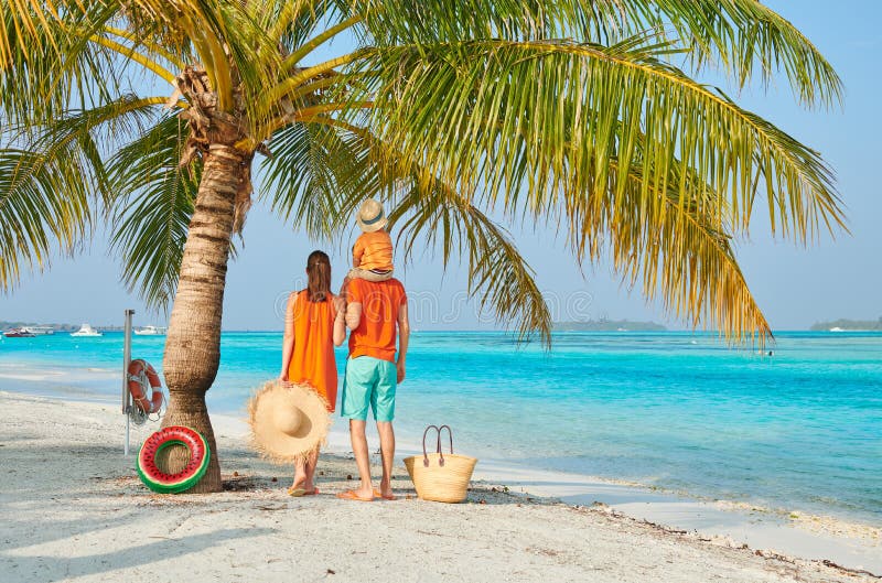 Familj av tre p? stranden under palmtr?det arkivfoton Familj av tre p? stranden under palmtr?det arkivfoton