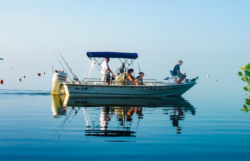 A Family in fishing boat on very calm water where the ocean blends into the sky off Cudjoe Key Florida USA circa August 2010. A Family in fishing boat on very calm water where the ocean blends into the sky off Cudjoe Key Florida USA circa August 2010