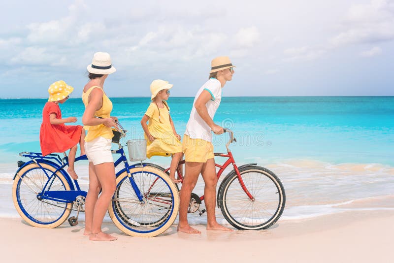 Familj med cykel på tropisk strand royaltyfri foto