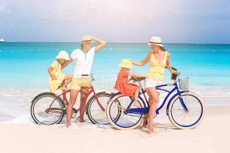 Familj med cykel på tropisk strand arkivfoton