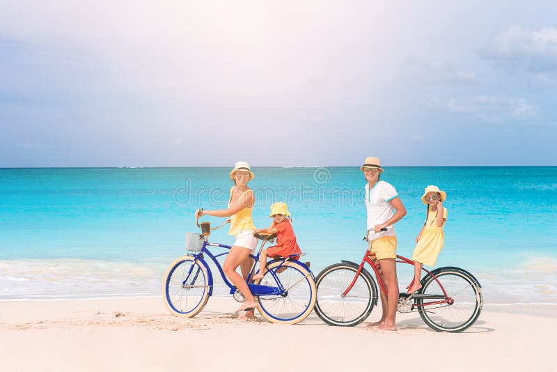 Familj med cykel på tropisk strand royaltyfria bilder