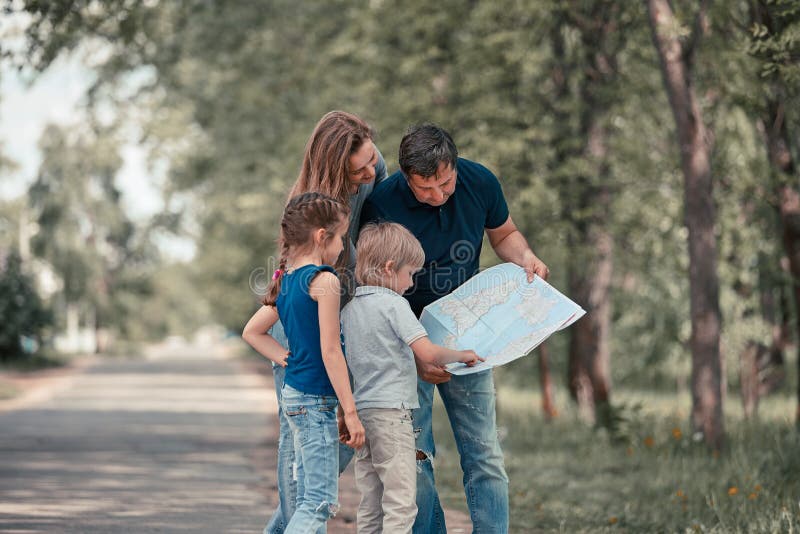 Familj med deras barn som diskuterar rutten p? ?versikten arkivbild Familj med deras barn som diskuterar rutten p? ?versikten arkivbild