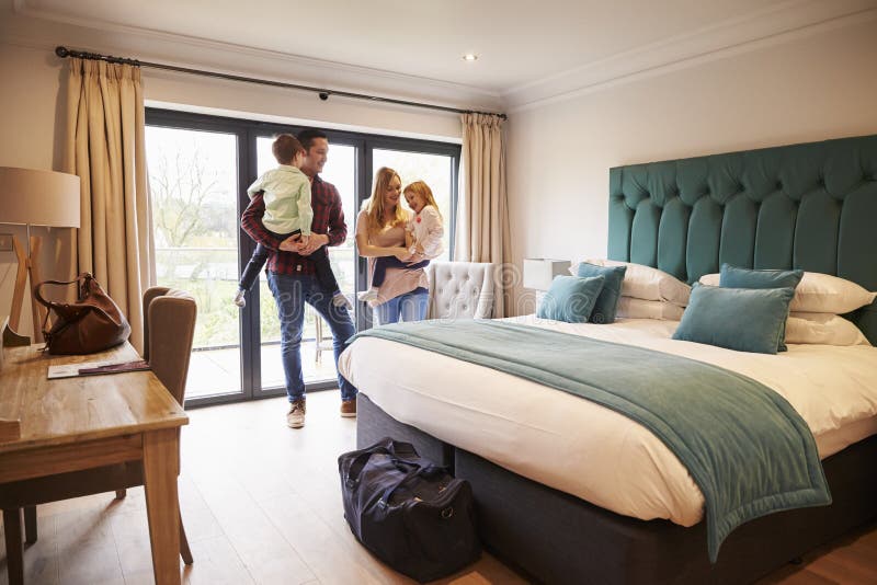 Familj som ankommer i hotellrum på semester fotografering för bildbyråer Familj som ankommer i hotellrum på semester fotografering för bildbyråer