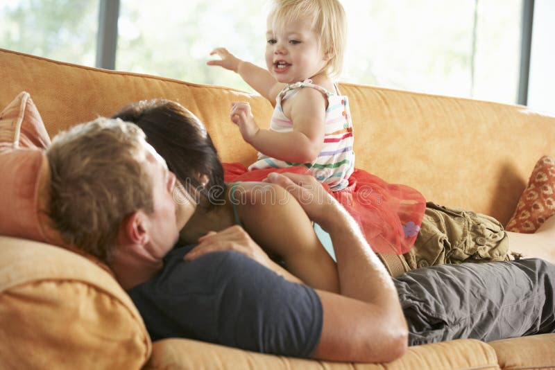 Familj som ligger på Sofa At Home royaltyfri bild Familj som ligger på Sofa At Home royaltyfri bild