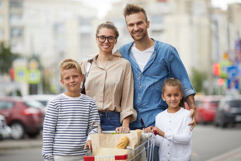Familj som poserar med det fria för shoppingvagn arkivfoton Familj som poserar med det fria för shoppingvagn arkivfoton
