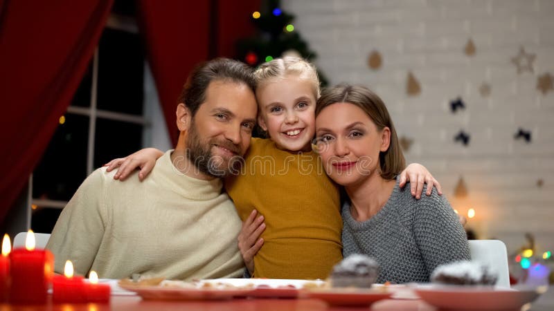 Familj som ser till kameran, julgran som bakom mousserar, lycklig folkstående fotografering för bildbyråer Familj som ser till kameran, julgran som bakom mousserar, lycklig folkstående fotografering för bildbyråer