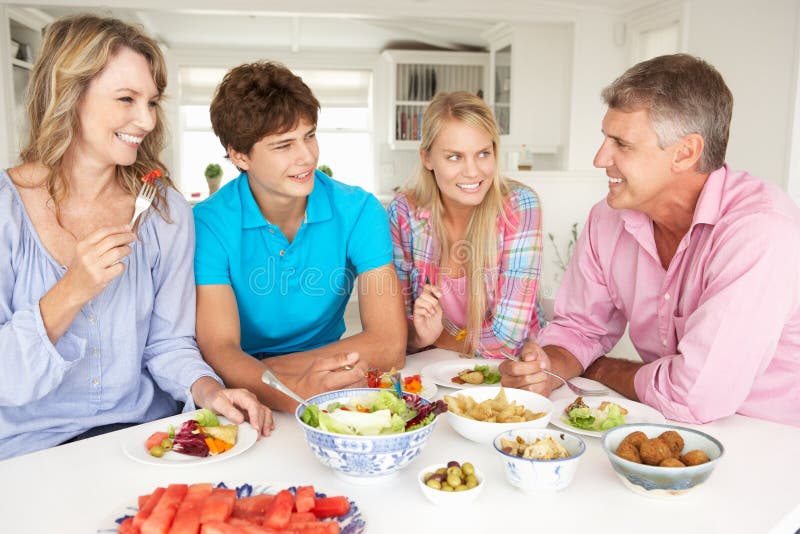 Family enjoying meal at home laughing and smiling. Family enjoying meal at home laughing and smiling