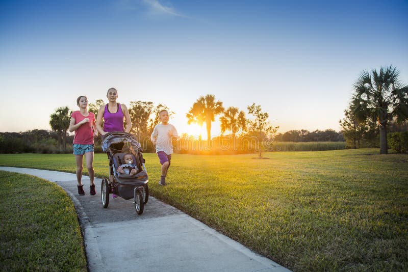 Familj som utomhus joggar och tillsammans övar
