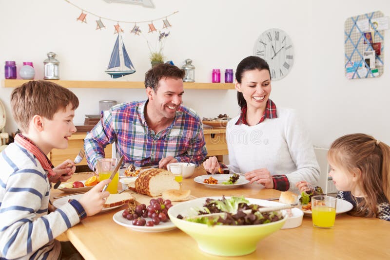 Familj som äter lunch på köksbordet arkivfoto Familj som äter lunch på köksbordet arkivfoto