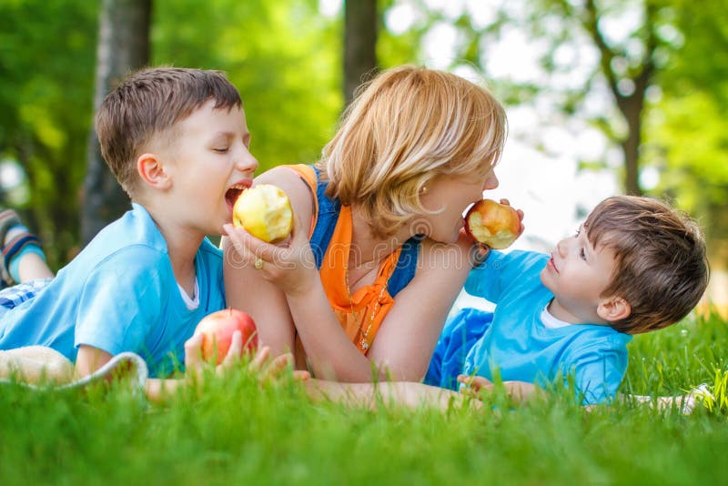 Mother with sons eating apple, healthy family. Mother with sons eating apple, healthy family