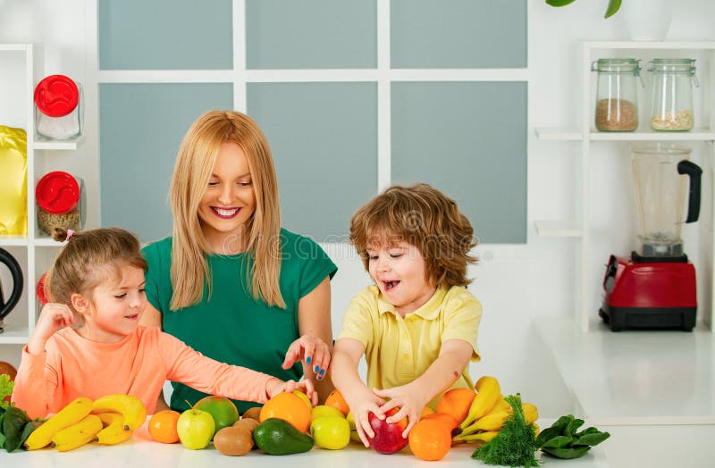Familjebegreppet supermat. hälsosam barnmat. moderdotter och liten son som förbereder frisk smoothie i modern fotografering för bildbyråer