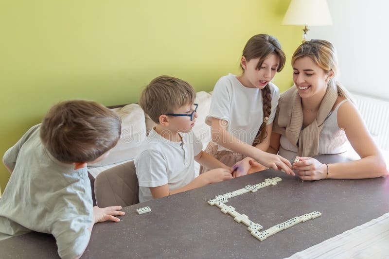 Familjelekar tillsammans hemma. Glad familj som njuter av ett roligt och pedagogiskt spel där man främjar royaltyfria bilder