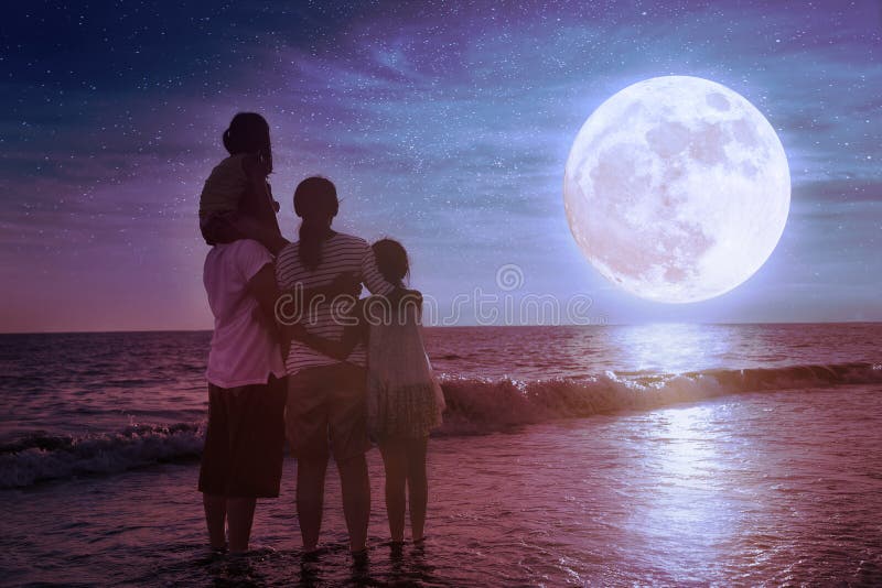 Familjen står på stranden och tittar på månen Fira Mid-höstfestival fotografering för bildbyråer Familjen står på stranden och tittar på månen Fira Mid-höstfestival fotografering för bildbyråer
