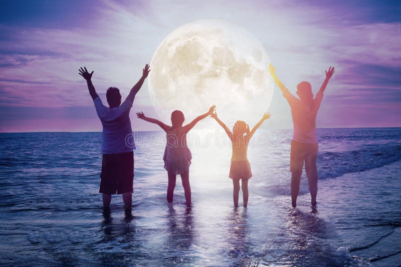 Familjen står på stranden och tittar på månen Fira Mid-höstfestival arkivbild Familjen står på stranden och tittar på månen Fira Mid-höstfestival arkivbild