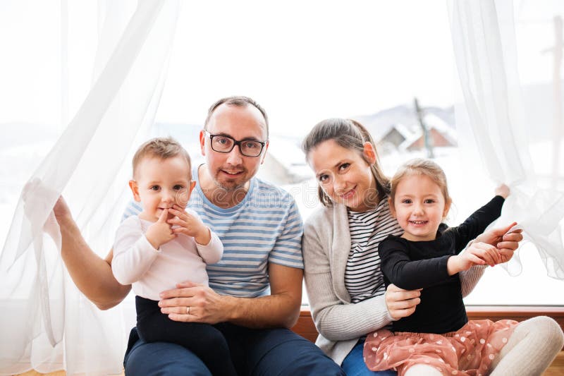 Familjeporträtt. Ungefär lyckad kärnfamilj med två barn. arkivfoto
