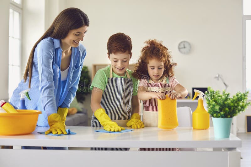 Mother and children cleaning room together and having fun. Kids helping parent to do domestic chores at home. House hygiene concept. Mother and children cleaning room together and having fun. Kids helping parent to do domestic chores at home. House hygiene concept