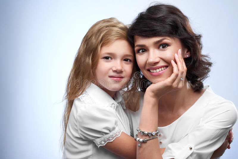 Familjfoto av le en moder och en heerälsklingdotter arkivbild Familjfoto av le en moder och en heerälsklingdotter arkivbild