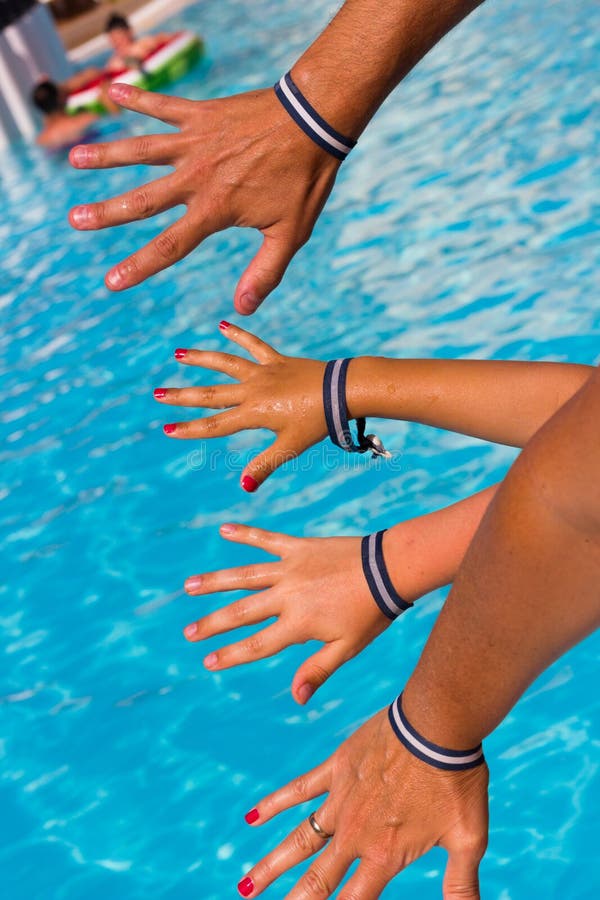 Familjhänder med alla inklusive armband av semesterortsimbassängen fotografering för bildbyråer Familjhänder med alla inklusive armband av semesterortsimbassängen fotografering för bildbyråer