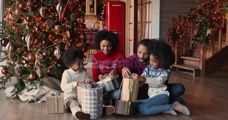 Famille africaine heureuse avec des enfants de l'ouverture de boîte célébrer Noël clips vidéos