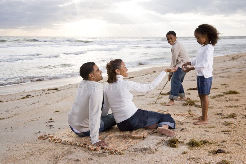 Famille afro-américaine heureuse jouant sur la plage images libres de droits Famille afro-américaine heureuse jouant sur la plage images libres de droits