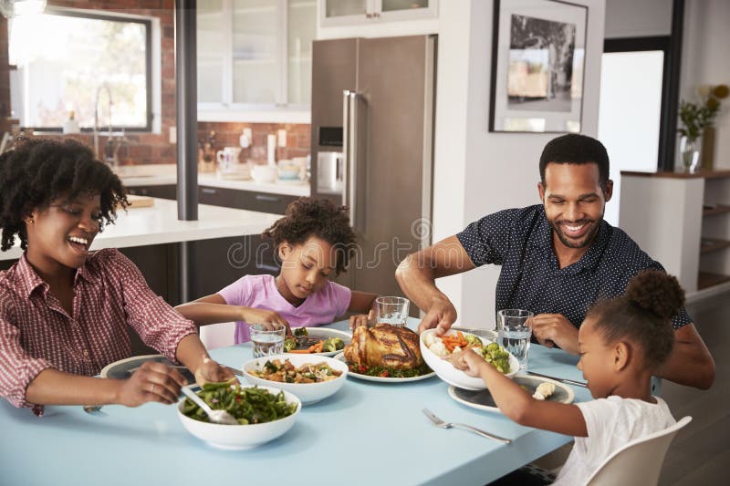 Famille appréciant le repas autour du Tableau à la maison ensemble photo stock Famille appréciant le repas autour du Tableau à la maison ensemble photo stock
