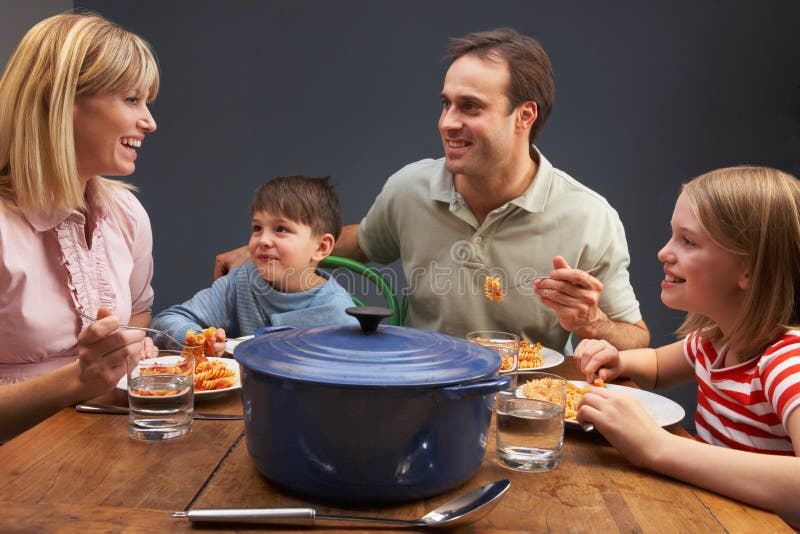 Famille appréciant le repas ensemble à la maison image libre de droits Famille appréciant le repas ensemble à la maison image libre de droits