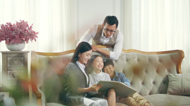 Famille asiatique avec le livre de lecture de deux enfants ensemble