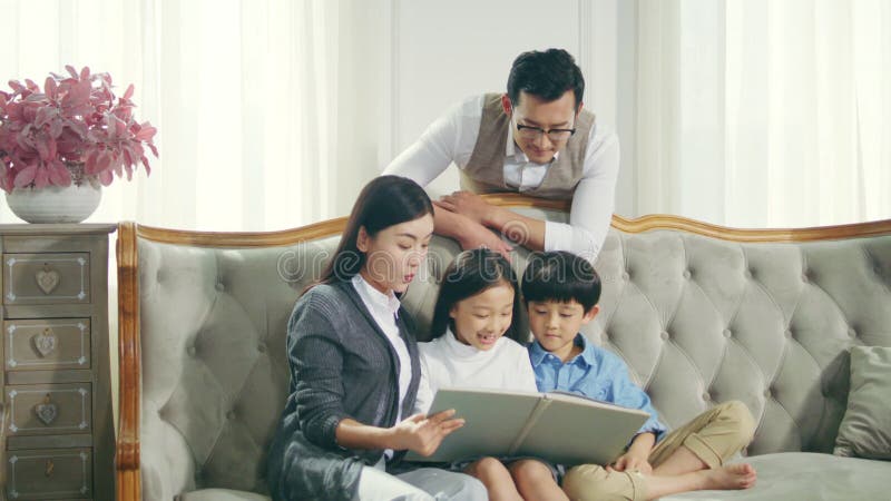 Famille asiatique avec le livre de lecture de deux enfants ensemble