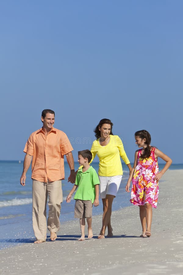 Famille avec des enfants marchant ayant l'amusement à la plage photo libre de droits