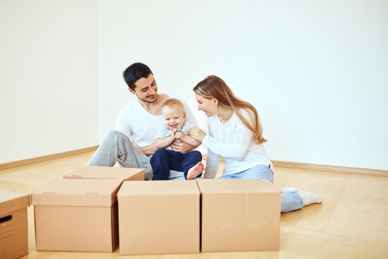 Famille avec le garçon déballant les cartons de déménagement à la nouvelle maison